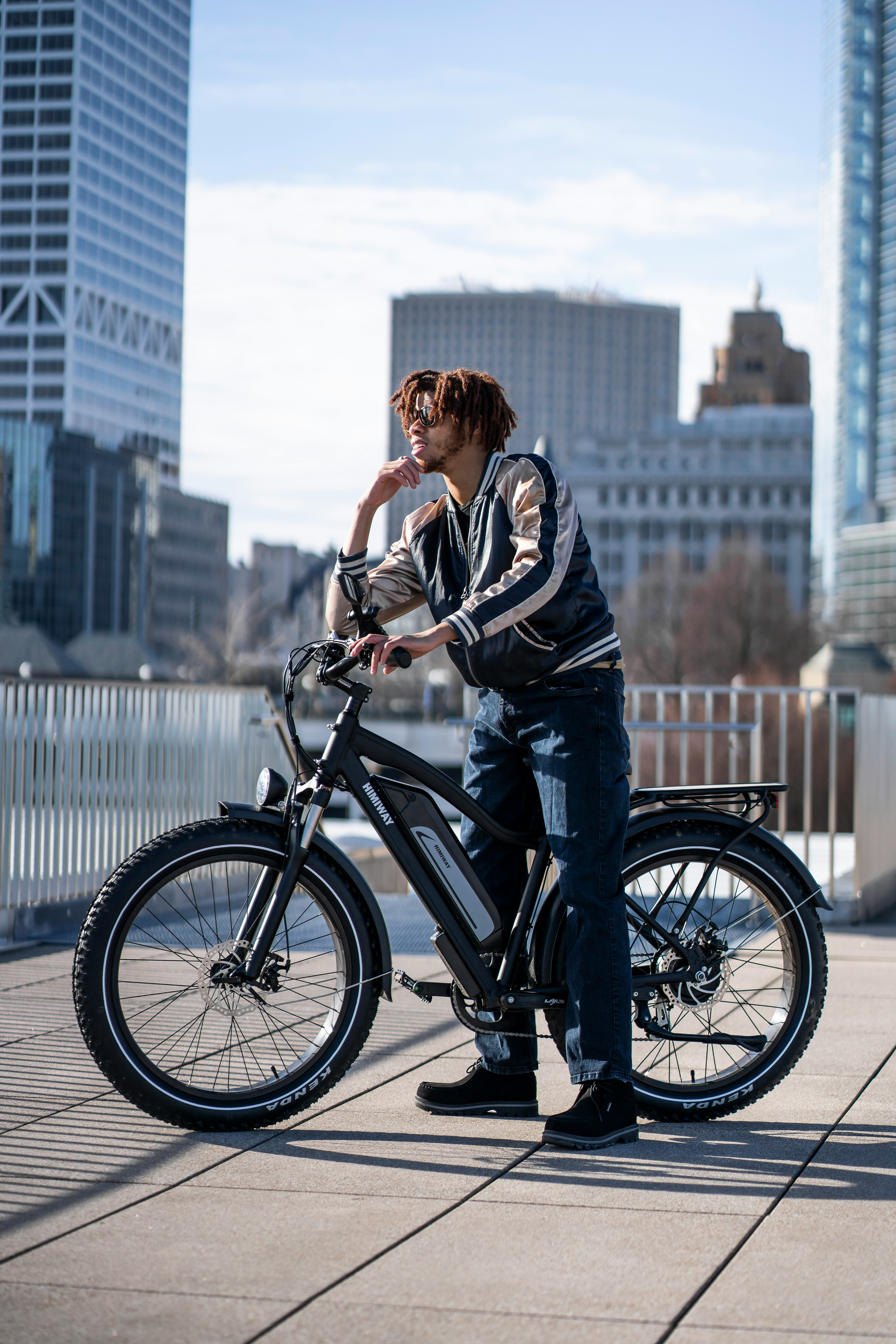 man in black and white jacket riding on black bicycle during daytime